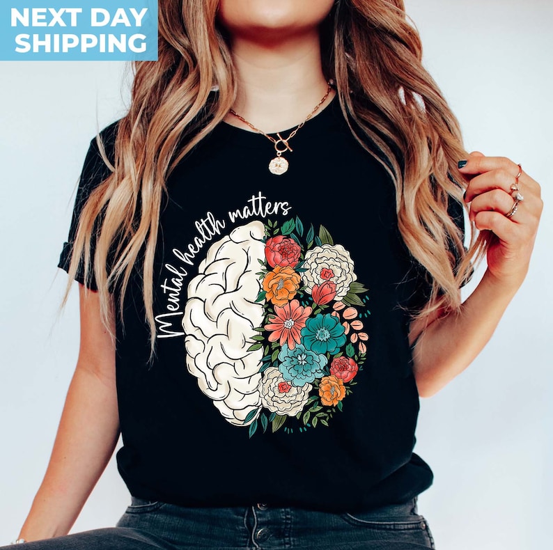 May include: Black t-shirt with a white brain outline filled with colorful flowers. The text "Mental health matters" is written around the brain.