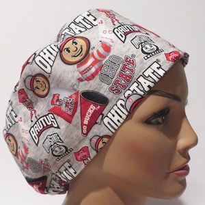 Peut inclure: Un bonnet de travail gris et rouge avec un motif répété du logo des Ohio State Buckeyes, de la mascotte Brutus Buckeye, et des mots "Ohio State" et "Go Bucks".