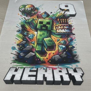 Peut inclure: Graphique coloré avec un personnage vert pixélisé, des diamants et un gâteau d'anniversaire. Le chiffre 9 et le nom "HENRY" sont également affichés. Le design comprend le texte "TNT" sur des ballons. L'image a un style vif et cartoon.