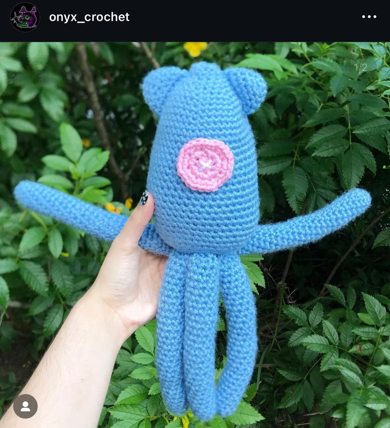 May include: A crocheted blue octopus with a pink circle in the centre of its body. The octopus has eight tentacles.