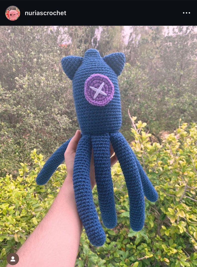 May include: A crocheted blue octopus plush toy with a purple button with a white X on it.