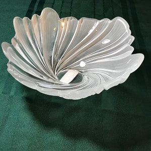 Puede incluir: Un cuenco de vidrio transparente con un dise&ntilde;o de espiral. El cuenco tiene forma de flor y tiene un acabado blanco esmerilado.