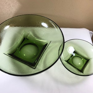 May include: Two green glass bowls with a square design in the center. The bowls are textured and have a frosted appearance.