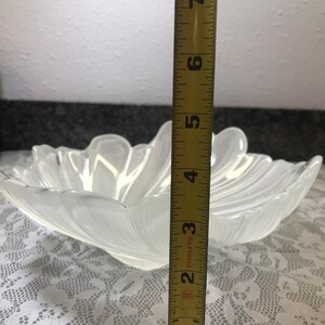 Puede incluir: Un cuenco de vidrio transparente con un borde festoneado y un dise&ntilde;o acanalado. El cuenco tiene un di&aacute;metro de aproximadamente 18 cm.