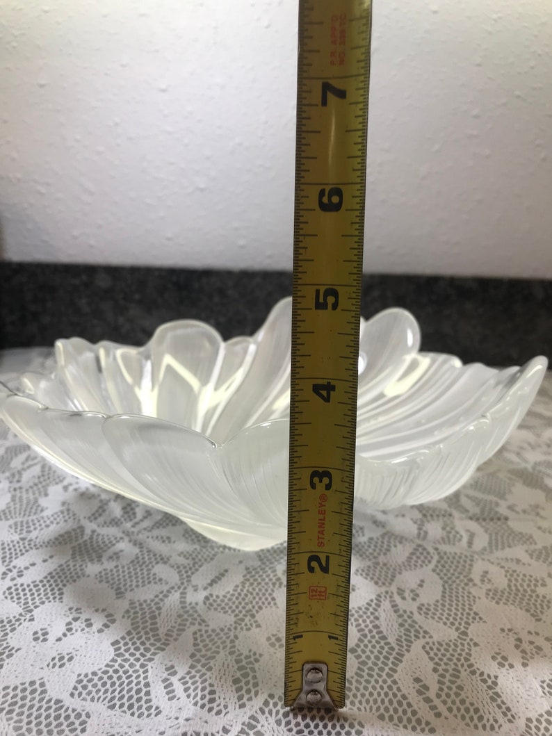 Puede incluir: Un cuenco de vidrio transparente con un borde festoneado y un dise&ntilde;o acanalado. El cuenco tiene un di&aacute;metro de aproximadamente 18 cm.