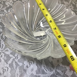 Puede incluir: Un cuenco de vidrio transparente con un dise&ntilde;o de espiral. El cuenco tiene un di&aacute;metro de aproximadamente 23 cm.