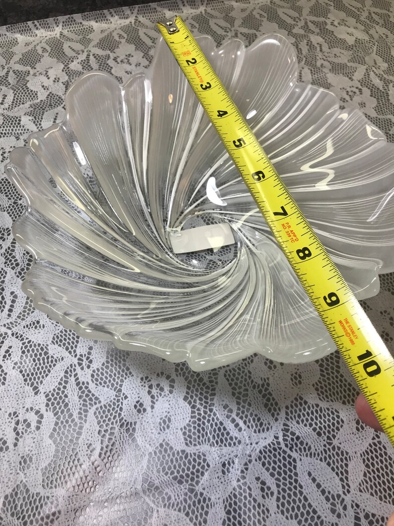 Puede incluir: Un cuenco de vidrio transparente con un dise&ntilde;o de espiral. El cuenco tiene un di&aacute;metro de aproximadamente 23 cm.