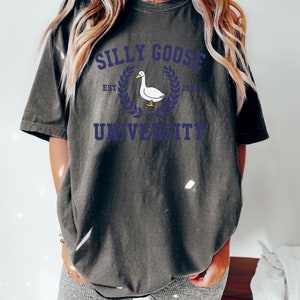 May include: A dark gray t-shirt with a white goose graphic and the text "Silly Goose University Est. 1992".