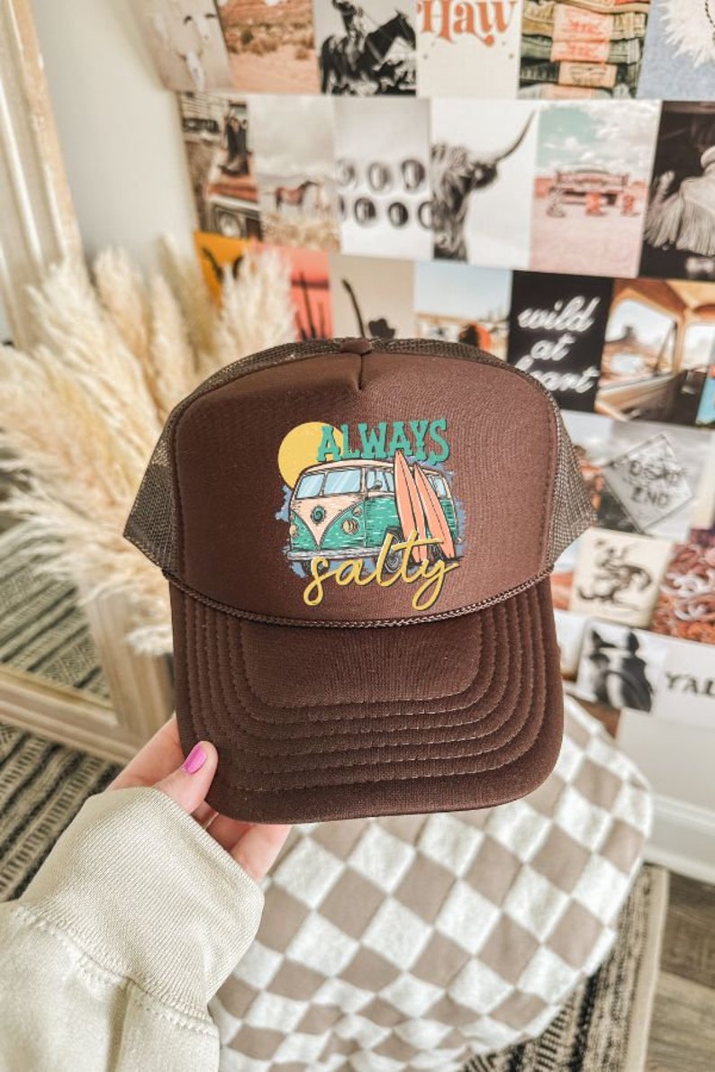 May include: Brown trucker hat with a green and yellow vintage van graphic and the text "Always Salty".