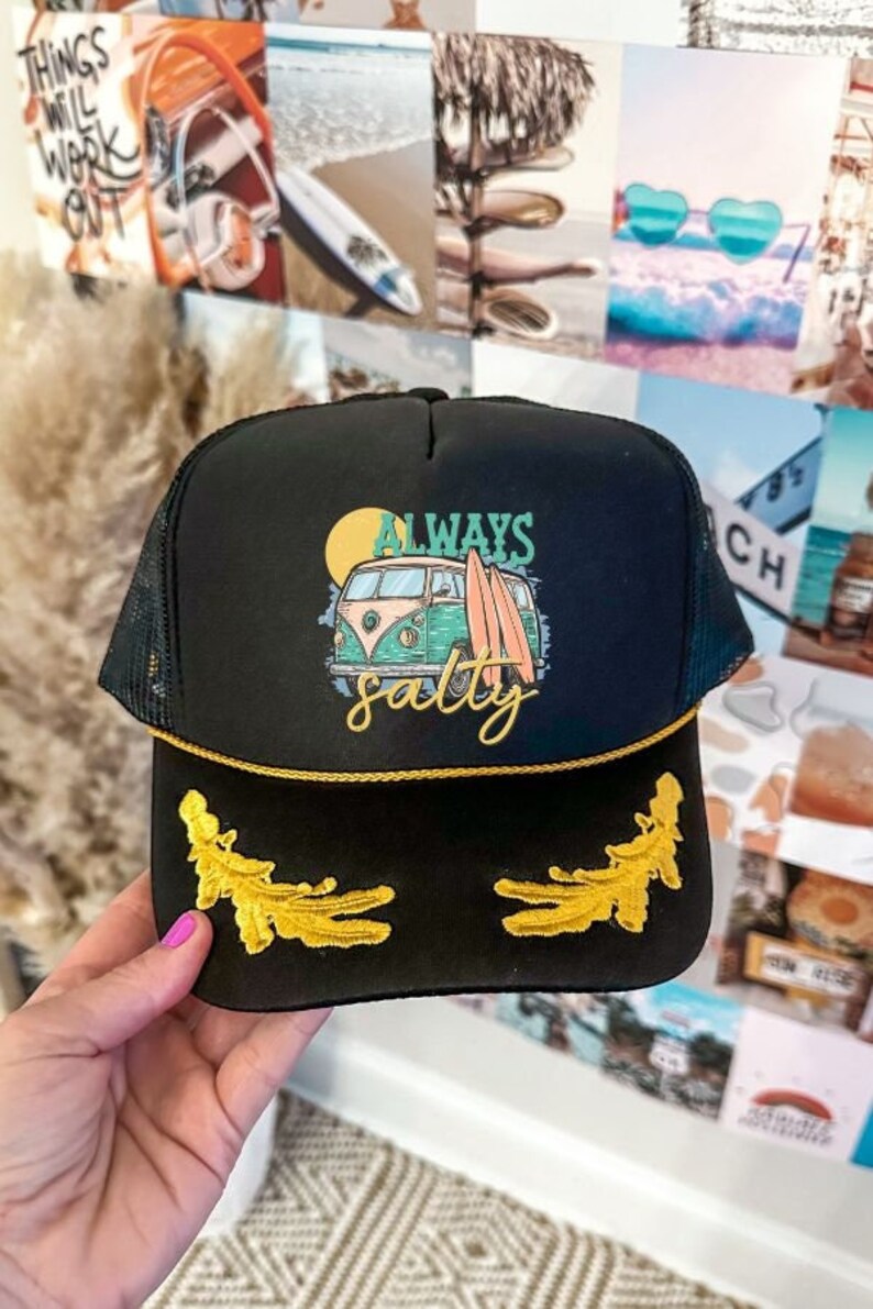 May include: Black trucker hat with a gold trim and a yellow, green, and blue graphic of a vintage van with surfboards and the text "ALWAYS salty".