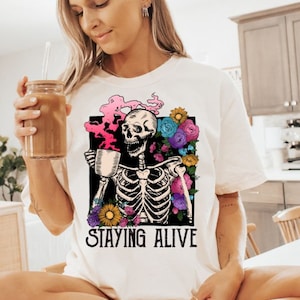 Camisa Staying Alive, camisa de café moderna, camiseta de esqueleto engraçada, presente para amantes de café, camiseta vintage de caveira para mulheres, camiseta com cores confortáveis