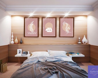 Può includere: Tre stampe incorniciate con uno sfondo rosa e illustrazioni bianche di foglie, una nave e una luna. Le stampe sono appese a una parete di legno sopra un letto con una coperta grigia.