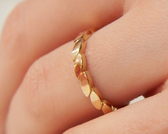 May include: A gold ring with a unique design featuring a series of connected oval shapes.
