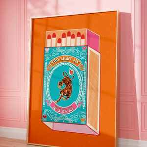 Puede incluir: Una ilustración de estilo vintage de una caja de cerillas con un tigre y el texto "You light my fire". La caja de cerillas es naranja con un diseño azul y rosa. El tigre es naranja y negro.