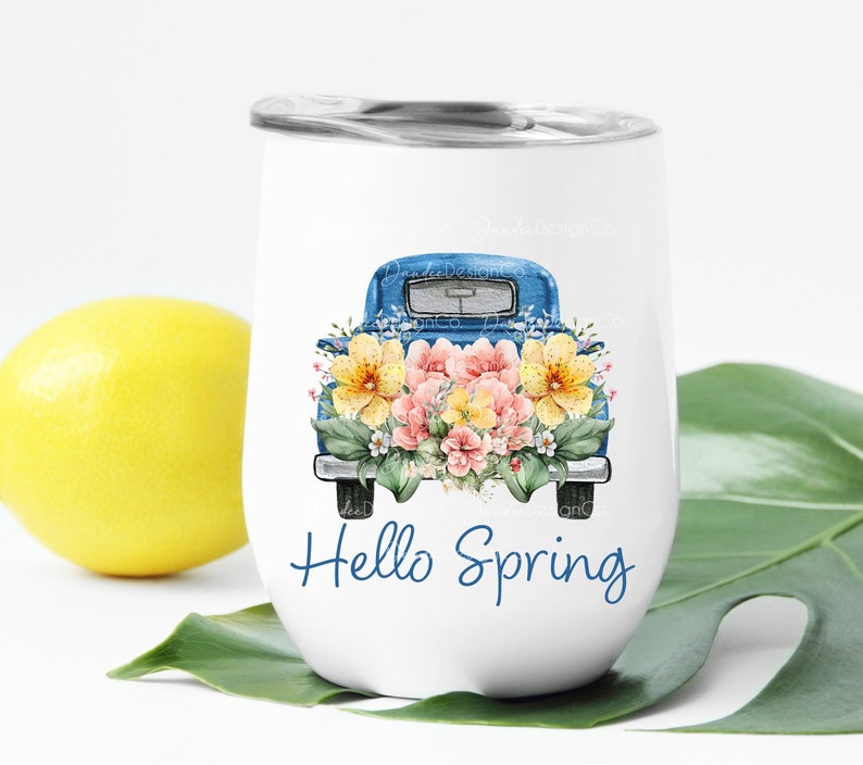 May include: White stainless steel tumbler with a blue pickup truck filled with pink and yellow flowers. The text "Hello Spring" is printed on the tumbler.