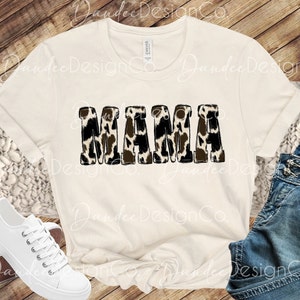Puede incluir: Una camiseta blanca con la palabra "MAMA" impresa en letras negras con un estampado de leopardo marr&oacute;n y blanco.
