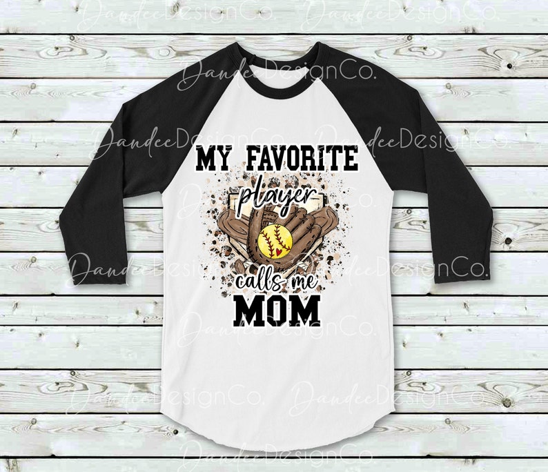 May include: White and black baseball raglan t-shirt with a brown and white graphic of a softball, glove, and baseball diamond. The graphic includes the text "My Favorite Player Calls Me Mom".