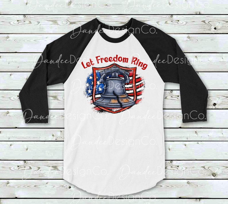 Puede incluir: Una camiseta de b&eacute;isbol blanca y negra con un dise&ntilde;o de bandera estadounidense roja, blanca y azul. La bandera tiene una campana en el centro y el texto "Let Freedom Ring" arriba.
