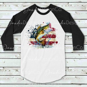 May include: A white and black baseball t-shirt featuring a design of a fish leaping out of water in front of a distressed American flag.