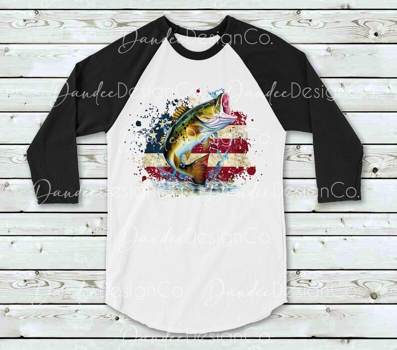 May include: A white and black baseball t-shirt featuring a design of a fish leaping out of water in front of a distressed American flag.