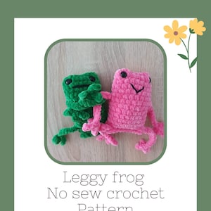 May include: Two crocheted frog plushies, one green and one pink, with long legs. The text 'Leggy frog No sew crochet Pattern' is below the frogs.