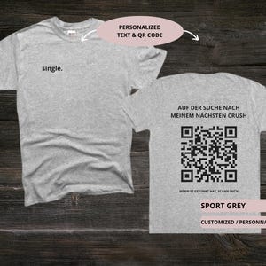 May include: Sport grey t-shirts with the word "single" on the front and a QR code on the back. The back of the shirt also has the text "AUF DER SUCHE NACH MEINEM N&Auml;CHSTEN CRUSH" and "WENN ES GEFUNKT HAT, SCANN MICH".