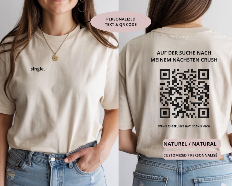 May include: Beige t-shirt with the word "single" printed on the front. The back of the shirt features a QR code and German text. The shirt also has the words "NATURAL" and "CUSTOMIZED" printed on it.