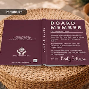 Peut inclure: Un livre de couleur bordeaux avec le titre "BOARD MEMBER" en blanc. Le livre présente une définition, des synonymes et une dédicace à Emily Johnson. Le côté gauche contient un texte de remerciement et le logo d'une ONG.