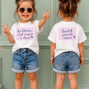 Peut inclure: Deux t-shirts blancs à manches courtes et shorts en jean bleu. Le t-shirt de gauche présente des rayures verticales roses et le texte "les bêtises, c'est mieux à deux" avec un cœur bleu. Celui de droite porte "bientôt grande soeur" avec un cœur.