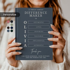 Peut inclure: Un cahier bleu foncé avec le texte "A Truly Great Difference Maker Is" et le nom "OLIVIA" avec des mots descriptifs. Le bas du cahier dit "Merci pour votre gentillesse, votre soutien et la personne que vous êtes."