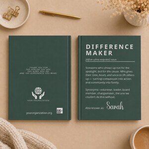 Peut inclure: Un journal vert foncé avec les mots "DIFFERENCE MAKER" et sa définition. Le journal contient également le texte "Merci pour la personne que vous êtes, le travail que vous faites et la différence que vous faites" et le nom "Sarah".