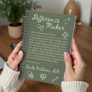 Könnte beinhalten: Ein spiralgebundenes Notizbuch mit einem salbeigrünen Einband mit den Worten "Difference Maker" in einer Schriftart. Das Notizbuch enthält eine Definition einer Krankenschwester und den Namen "Emily Watson, RN".