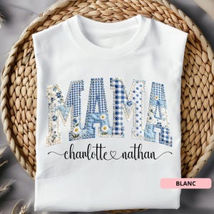 Op de afbeelding: Wit T-shirt met het woord "MAMA" in patchwork letters, met bloemen-, ruit- en stippatronen in blauw en wit. Daaronder staan de namen "charlotte & nathan" in een scriptlettertype.