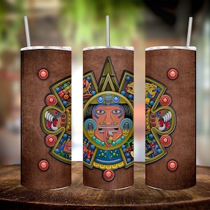 Puede incluir: Tres vasos de acero inoxidable con fondo marrón y un diseño azteca colorido que presenta una cara central con una lengua grande. El diseño está rodeado de formas geométricas y símbolos.