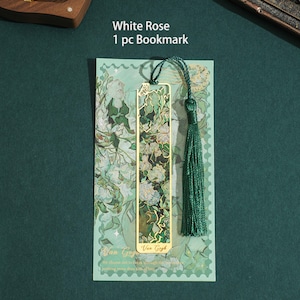 May include: A gold bookmark with a green and white floral design. The bookmark has a green tassel and the text "White Rose 1 pc Bookmark" and "Van Gogh" on the card.