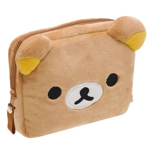 May include: A brown, bear-shaped pencil case with a zip. The bear has black eyes, a white muzzle, and a black mouth. The ears have yellow accents. The case is rectangular and made of soft material.