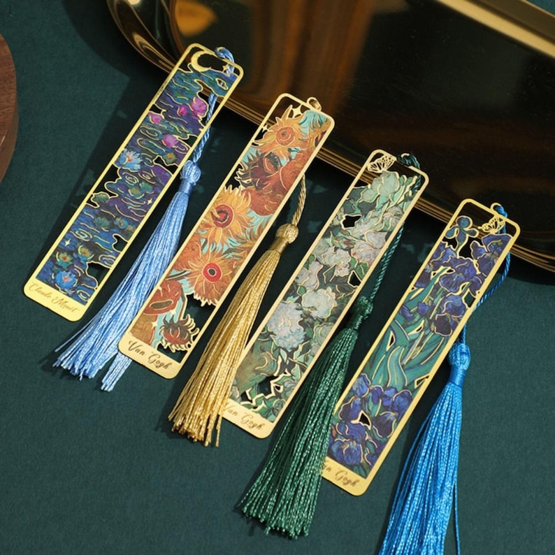 May include: Set of five gold metal bookmarks with colorful images of famous paintings and tassels. The bookmarks feature works by Van Gogh, including "Starry Night" and "Sunflowers".