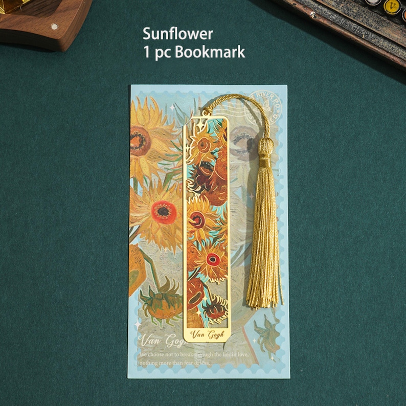 May include: Gold bookmark featuring a painting of sunflowers by Van Gogh. The bookmark has a tassel and the text "Van Gogh" and "We choose not to break through the simple love, nothing more than four firs."