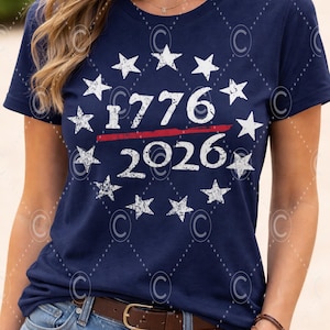 Pode incluir: Camiseta azul marinho com estrelas brancas que circundam os números "1776" e "2026", separados por uma linha vermelha. A camiseta é de estilo gola redonda.