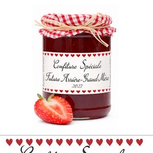 Peut inclure: Un pot en verre rempli de confiture de fraise rouge, surmonté d'un couvercle en tissu à carreaux rouges et blancs noué avec une ficelle en raphia. L'étiquette porte des cœurs rouges et le texte Confiture Spéciale Future Arrière-Grand-Mère 2027.
