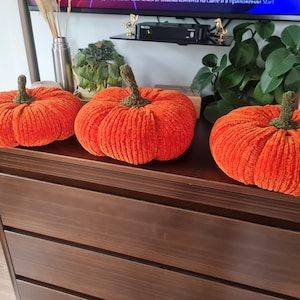 three pumpkins cushions on the shelf
