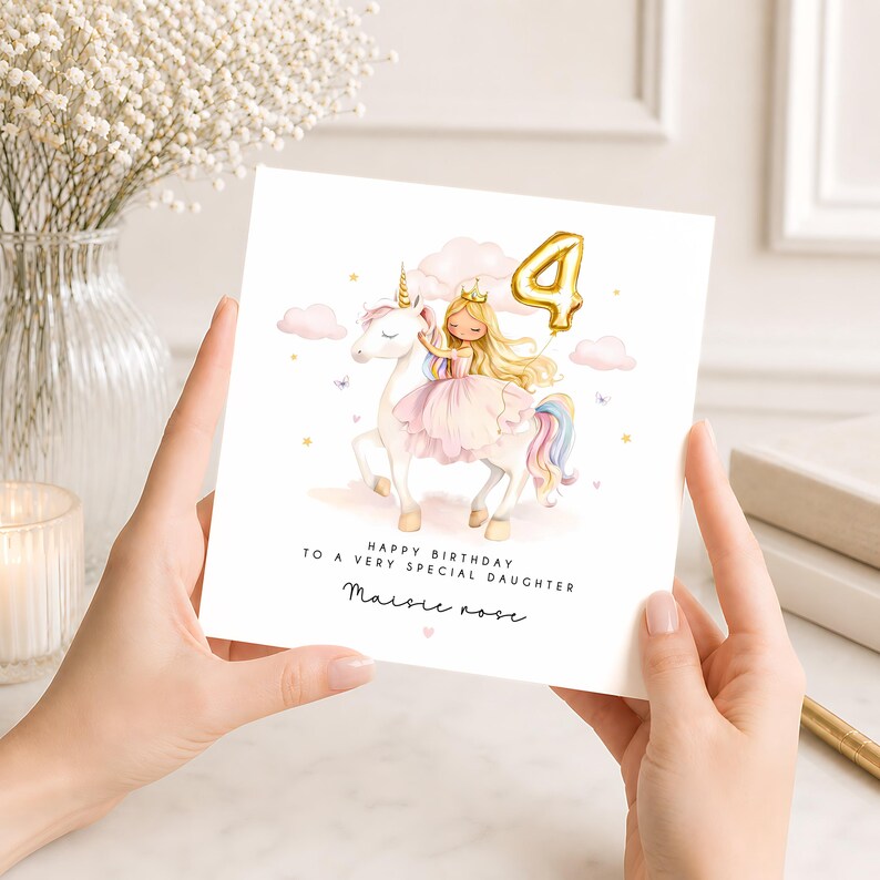 May include: A square birthday greeting card featuring a watercolor illustration of a girl with long blonde hair wearing a crown and pink dress riding a white unicorn. A gold balloon shaped like the number 4 floats above. Text reads: Happy Birthday to a very special daughter, Maisie Rose.