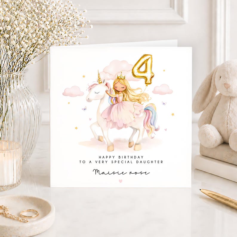 May include: A square birthday greeting card featuring a watercolor illustration of a girl with blonde hair and a crown riding a white unicorn. A gold balloon shaped like the number 4 floats above. Text reads: HAPPY BIRTHDAY TO A VERY SPECIAL DAUGHTER Maisie rose.