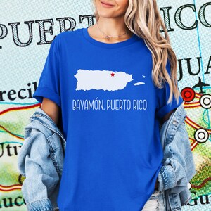 May include: A royal blue t-shirt with a white outline of Puerto Rico and the text "Bayamón, Puerto Rico".