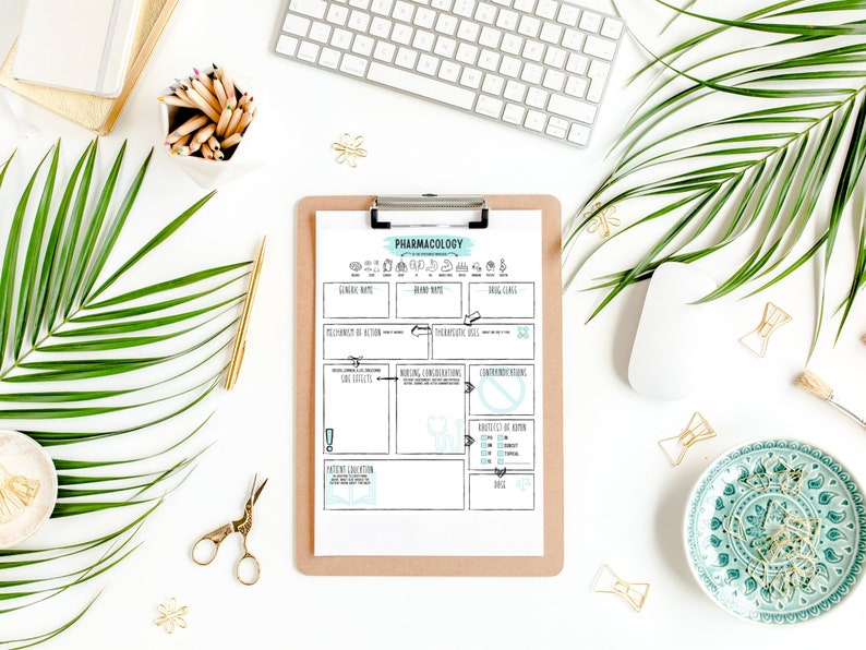 May include: A clipboard with a "Pharmacology" chart, surrounded by office supplies. The chart has a teal and black design with labeled sections. A white keyboard, mouse, and pencils are also visible. Gold scissors, paper clips, and a decorative plate add detail.