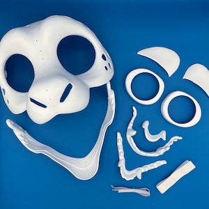 K&ouml;nnte beinhalten: Wei&szlig;e Plastikmaskenst&uuml;cke f&uuml;r ein Fellkost&uuml;m. Die Teile umfassen Kopf, Ohren, Nase und Mund.