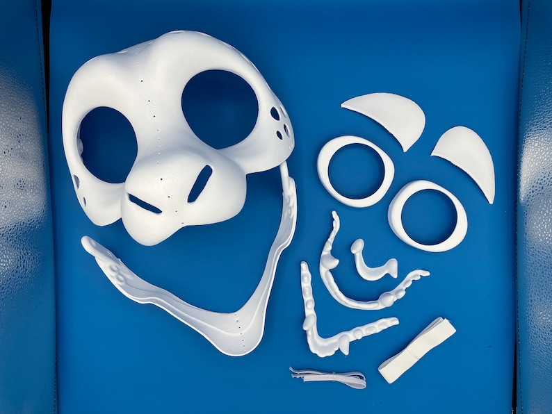 K&ouml;nnte beinhalten: Wei&szlig;e Plastikmaskenst&uuml;cke f&uuml;r ein Fellkost&uuml;m. Die Teile umfassen Kopf, Ohren, Nase und Mund.