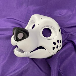 Op de afbeelding: Witte ongeverfde harige dierenmasker met een zwarte neus en ooggaten. Het masker heeft een textuur en is gemaakt van een hard materiaal.