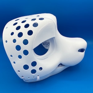 K&ouml;nnte beinhalten: Wei&szlig;e, unbemalte Felltiermaske mit gepunktetem Muster und L&ouml;chern f&uuml;r Augen und Nase. Die Maske besteht aus einem glatten, harten Material und hat eine realistische Form.