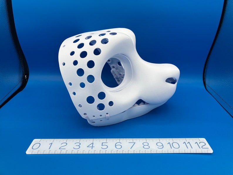 K&ouml;nnte beinhalten: Wei&szlig;e, unfertige Felltiermaske mit ausgeh&ouml;hltem Augen- und Mundbereich. Die Maske hat ein gepunktetes Muster und ist aus hartem Kunststoff.